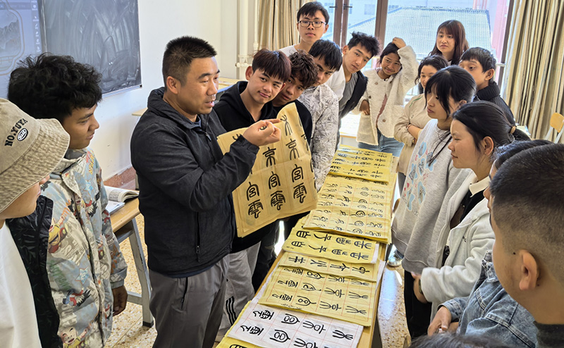 徐润刚用手语为学生们讲解书法篆刻。taptap点点体育供图
